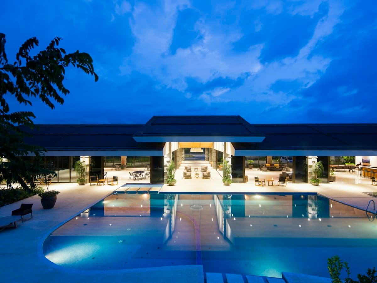 A hotel pool at dusk, lit from below