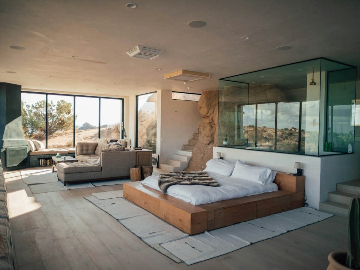 A bright bedroom with a glass-walled bathroom